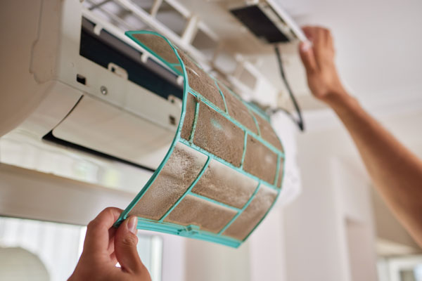 monteur vervangt vervuilde airco filter tijdens onderhoud
